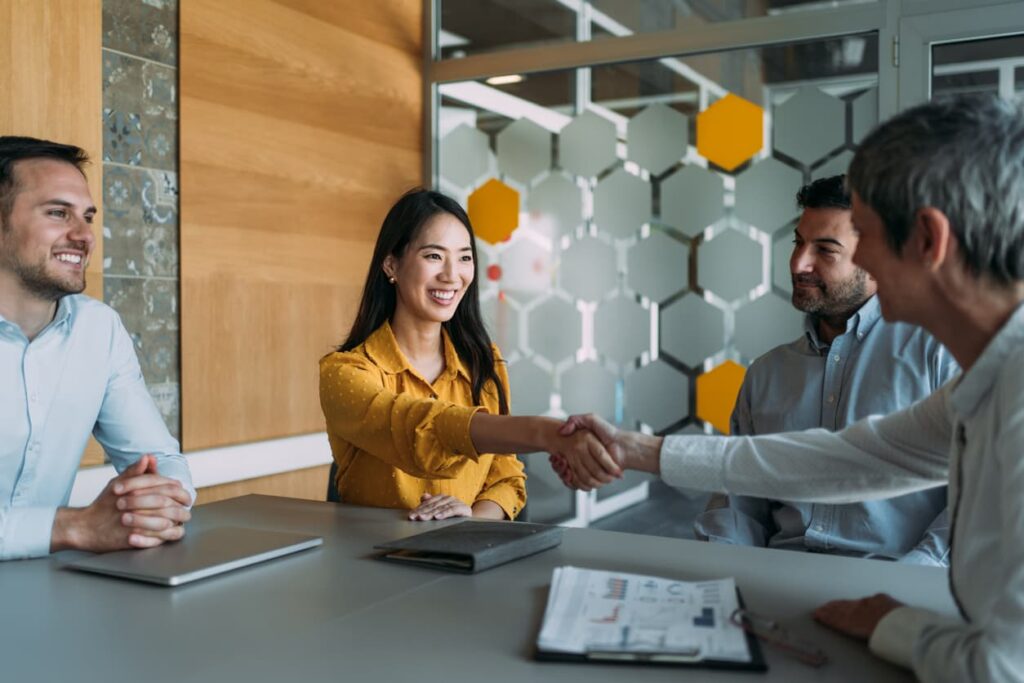Job candidate and employer shaking hands at job interview