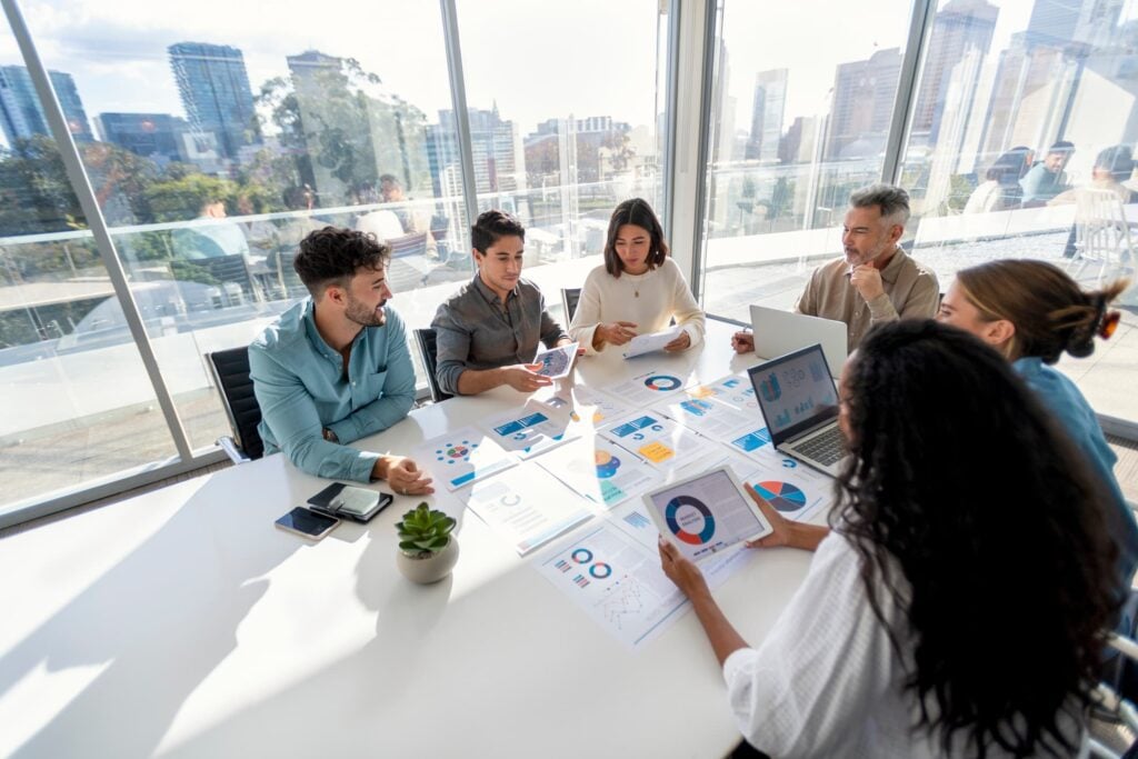 Finance team reviewing charts and financial reports during a strategy meeting in a modern conference room