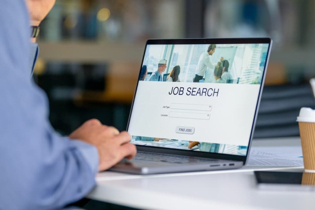 Professional reviewing an online job search portal on a laptop