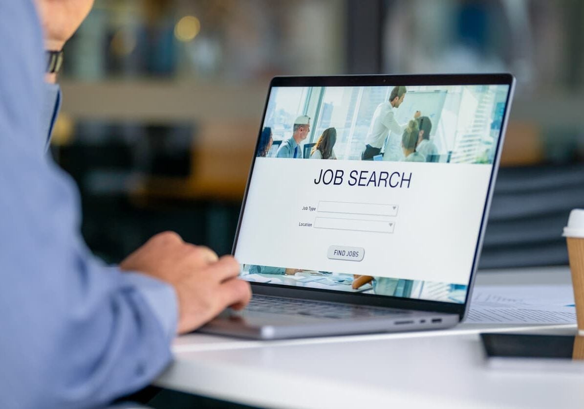 Professional reviewing an online job search portal on a laptop