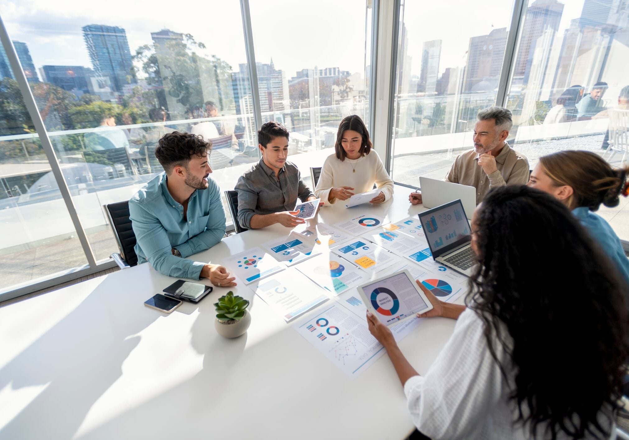Finance team reviewing charts and financial reports during a strategy meeting in a modern conference room