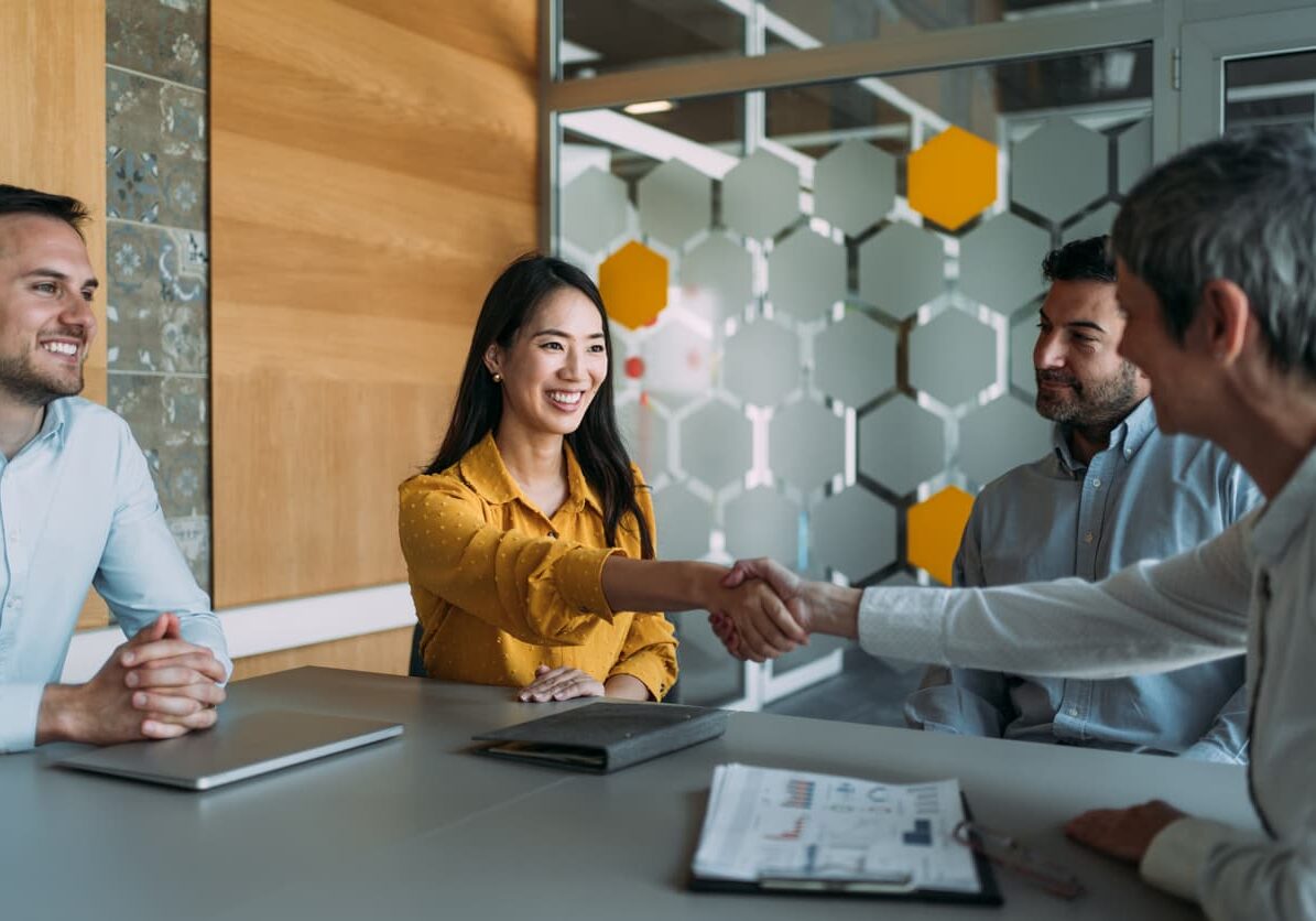 Job candidate and employer shaking hands at job interview